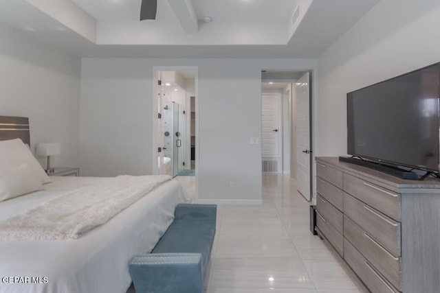 bedroom with ceiling fan, light tile patterned flooring, a raised ceiling, and ensuite bath