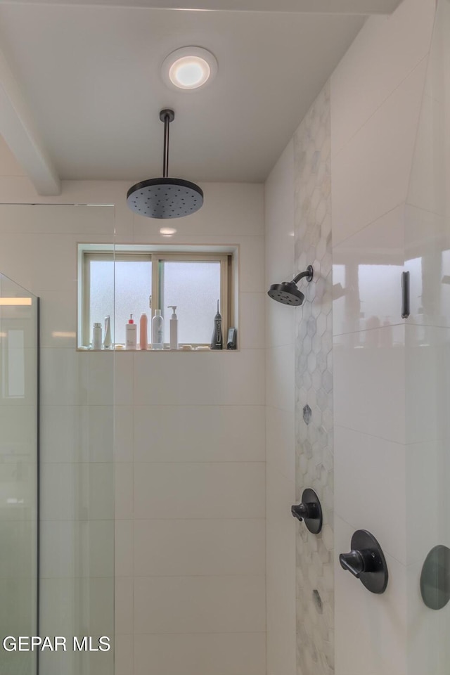 bathroom featuring a wealth of natural light and tiled shower