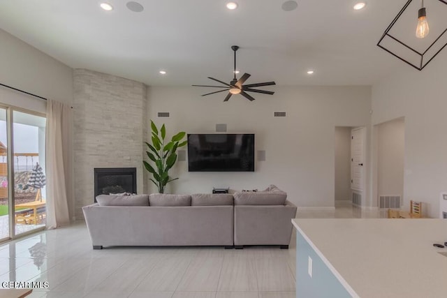 living room featuring ceiling fan and a fireplace