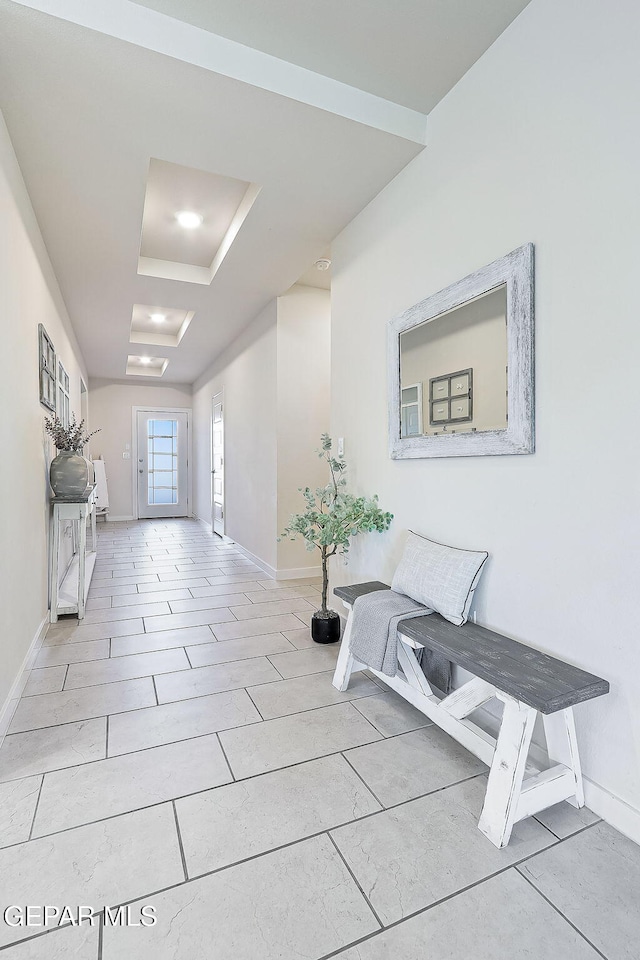 hallway featuring a tray ceiling