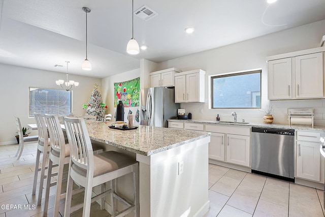 kitchen with white cabinetry, a kitchen island, pendant lighting, and appliances with stainless steel finishes