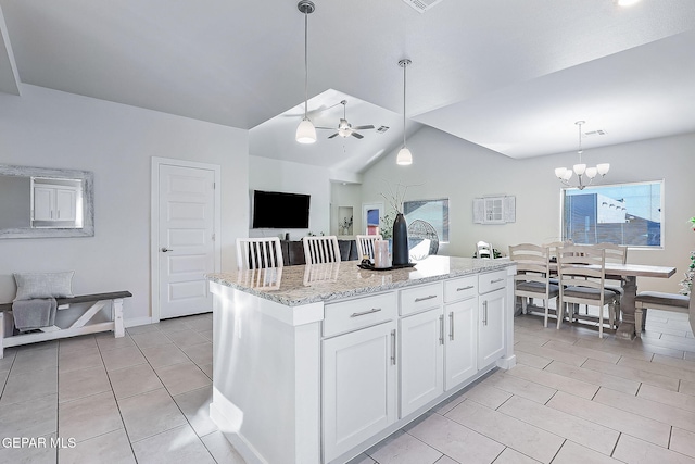 kitchen with pendant lighting, a center island, white cabinetry, and vaulted ceiling