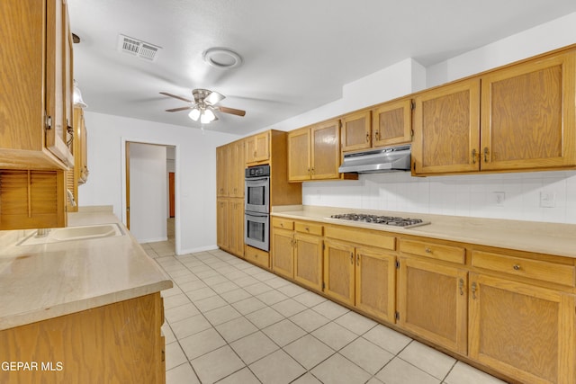 kitchen featuring backsplash, sink, ceiling fan, light tile patterned floors, and stainless steel appliances