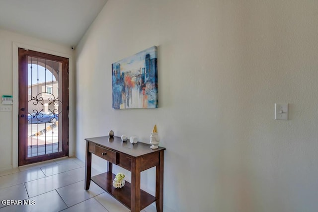 tiled entrance foyer featuring vaulted ceiling