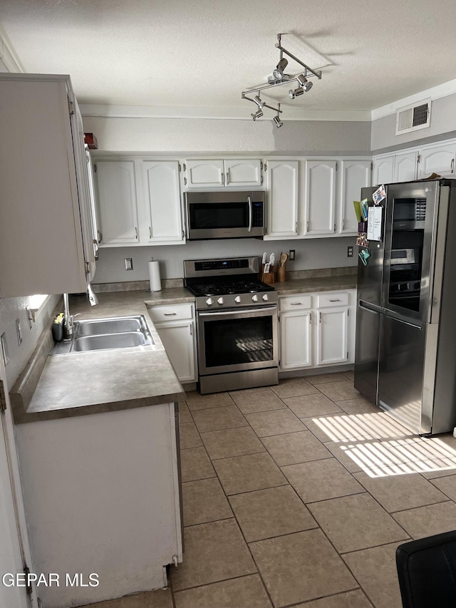 kitchen featuring stainless steel appliances, white cabinetry, and sink