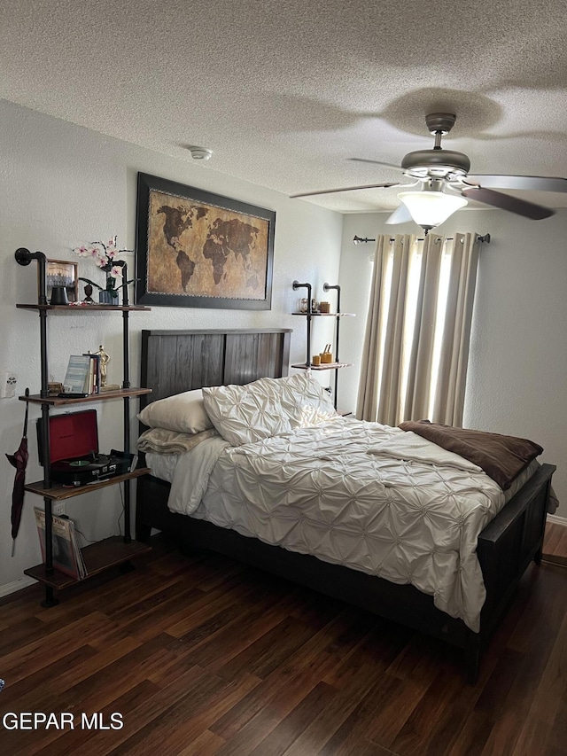 bedroom with ceiling fan, a textured ceiling, and dark hardwood / wood-style floors