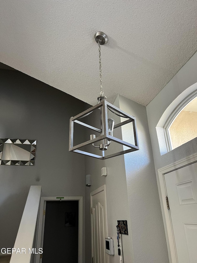 room details featuring a textured ceiling and a chandelier