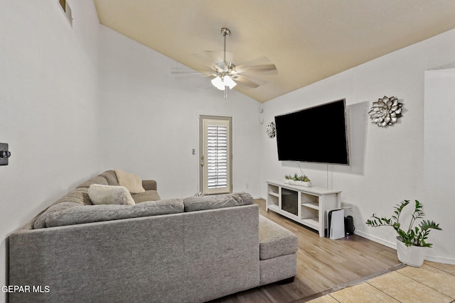 living room with ceiling fan, hardwood / wood-style floors, and vaulted ceiling