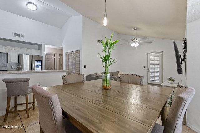 dining room with light tile patterned floors, high vaulted ceiling, ceiling fan, and sink