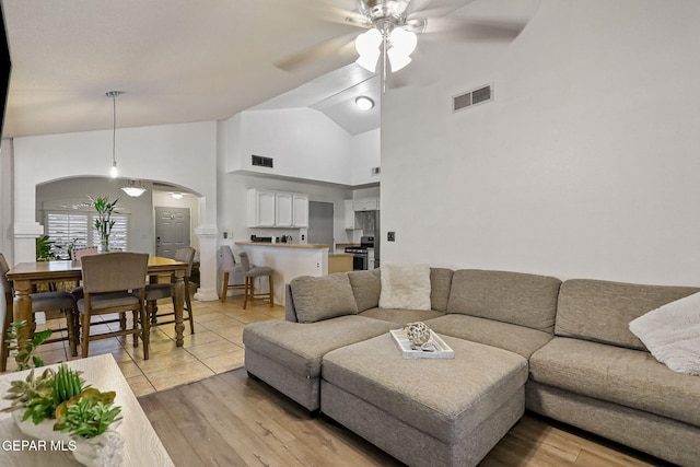 living room with high vaulted ceiling, light hardwood / wood-style flooring, and ceiling fan