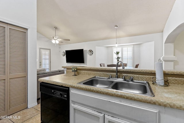 kitchen featuring ceiling fan, sink, black dishwasher, vaulted ceiling, and light tile patterned floors