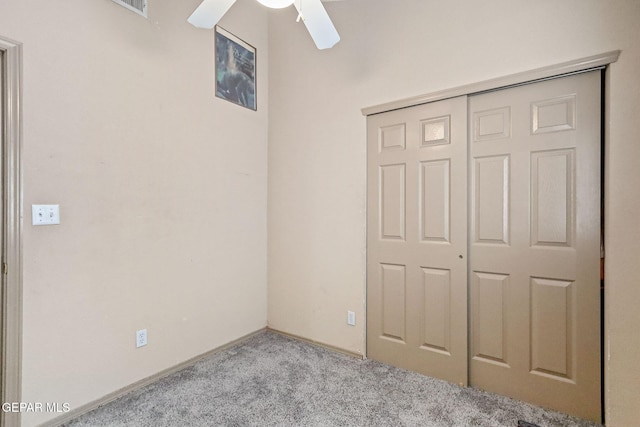 unfurnished bedroom featuring ceiling fan, light colored carpet, and a closet