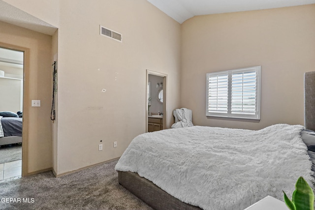 bedroom featuring carpet flooring, high vaulted ceiling, and ensuite bath