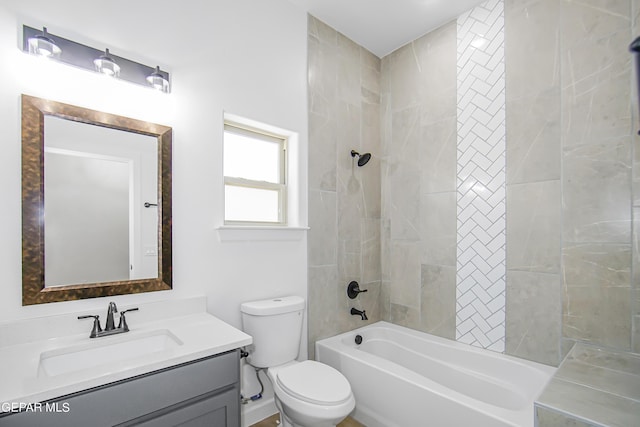 full bathroom featuring vanity, tiled shower / bath, and toilet