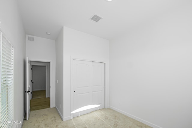 unfurnished room featuring light colored carpet