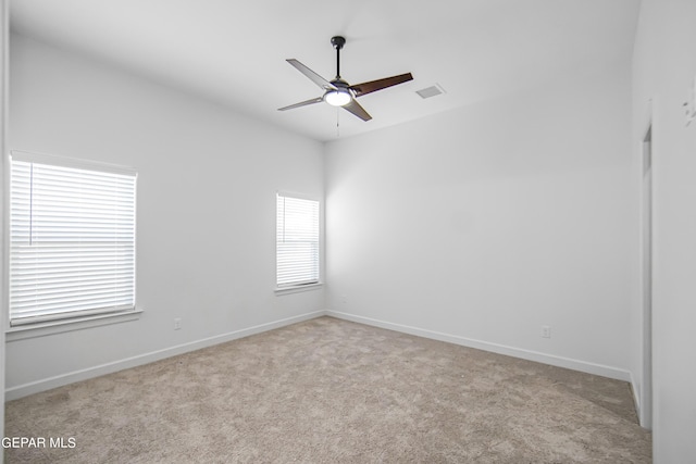 carpeted spare room featuring ceiling fan