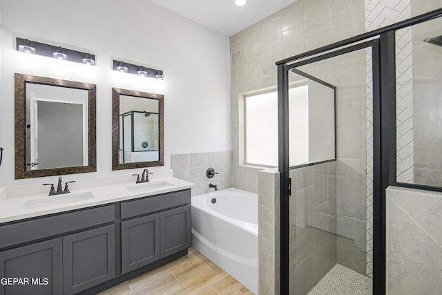 bathroom with hardwood / wood-style floors, vanity, and independent shower and bath