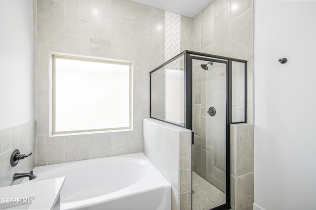 bathroom featuring vanity and independent shower and bath