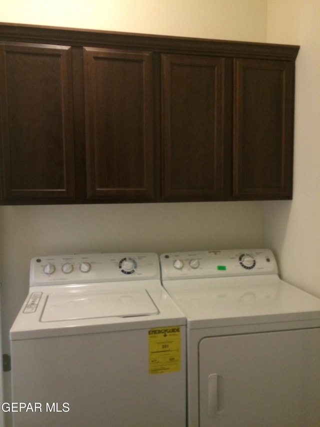 laundry area featuring washer and dryer and cabinets