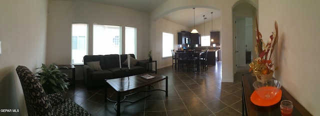 living room with dark tile patterned floors and vaulted ceiling