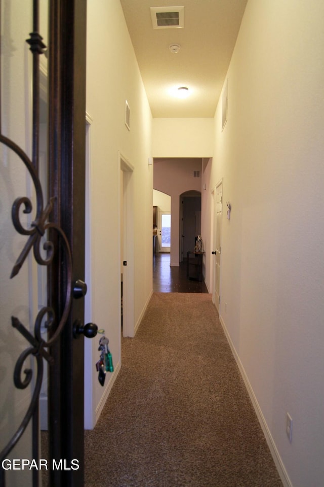 hall featuring dark colored carpet