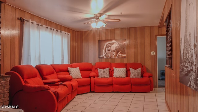 tiled living room featuring ceiling fan and wood walls