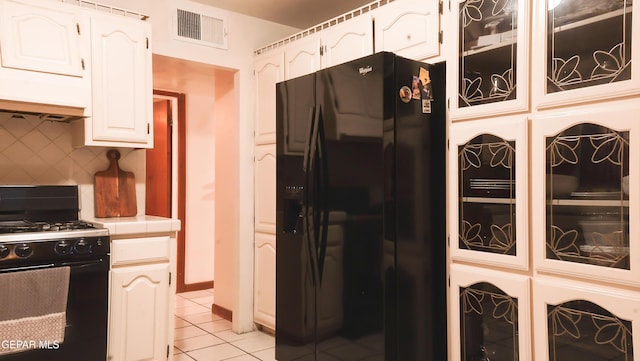 kitchen featuring white cabinetry, tile countertops, light tile patterned floors, decorative backsplash, and black appliances