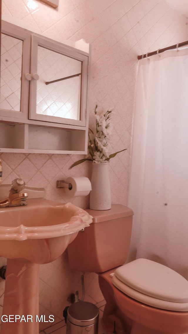 bathroom with tile walls, backsplash, and toilet