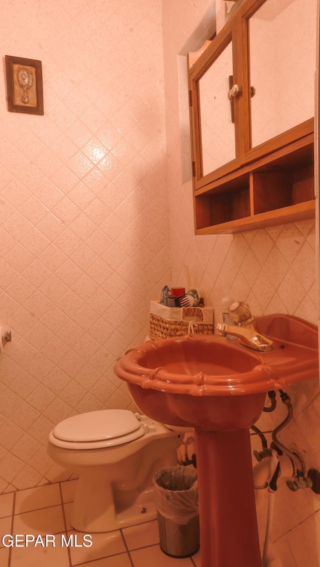 bathroom featuring tile walls, tile patterned floors, and toilet