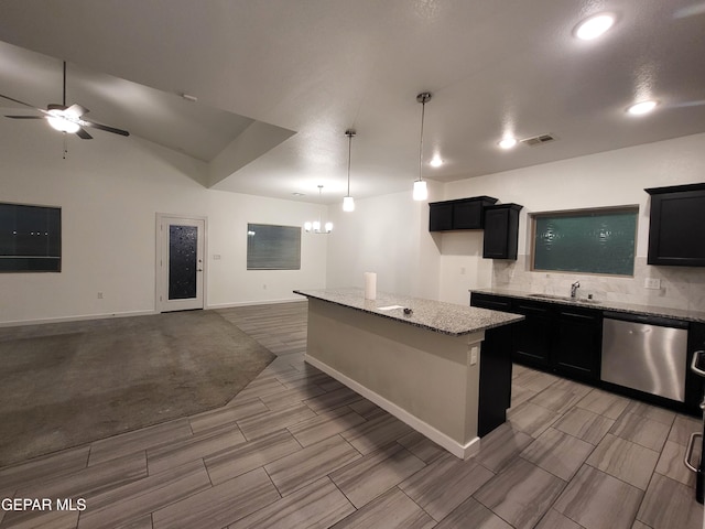 kitchen featuring light stone counters, sink, dishwasher, a kitchen island, and hanging light fixtures