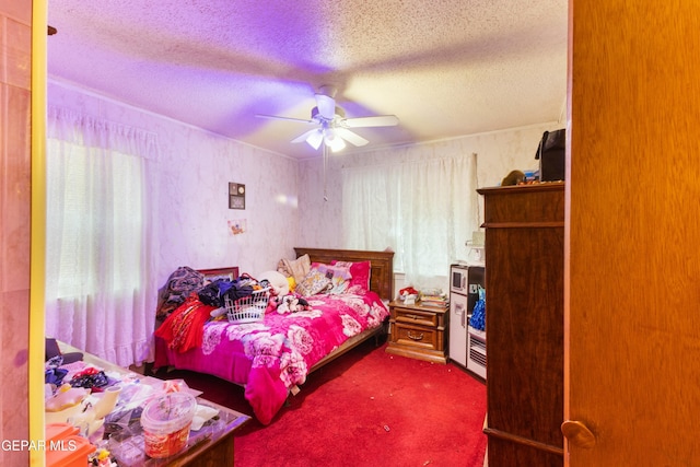 carpeted bedroom featuring ceiling fan and a textured ceiling