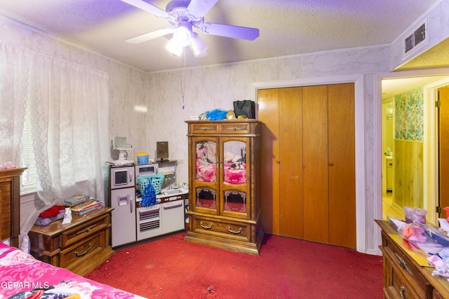 carpeted bedroom featuring a textured ceiling, a closet, and ceiling fan