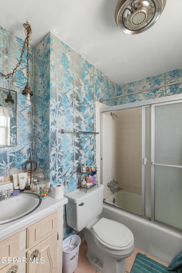 full bathroom featuring tile patterned floors, vanity, toilet, and bath / shower combo with glass door