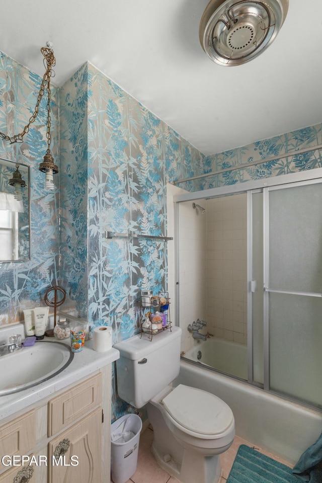 full bathroom with shower / bath combination with glass door, tile patterned flooring, vanity, and toilet