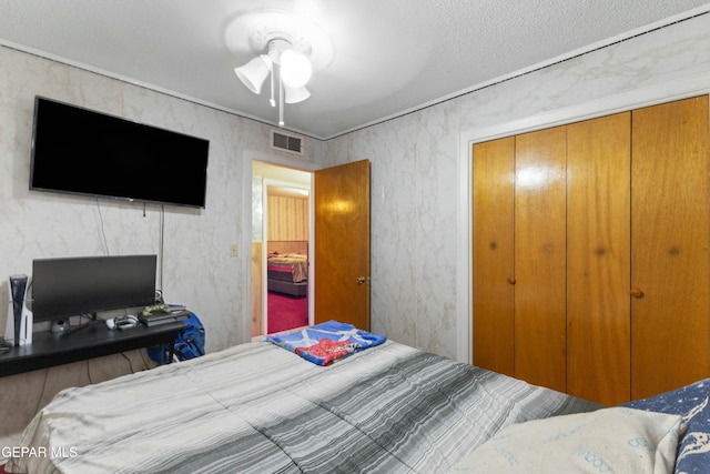 bedroom featuring ceiling fan, a closet, and a textured ceiling