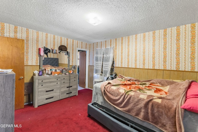 carpeted bedroom featuring wood walls and a textured ceiling