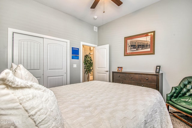 carpeted bedroom with ceiling fan, lofted ceiling, and a closet