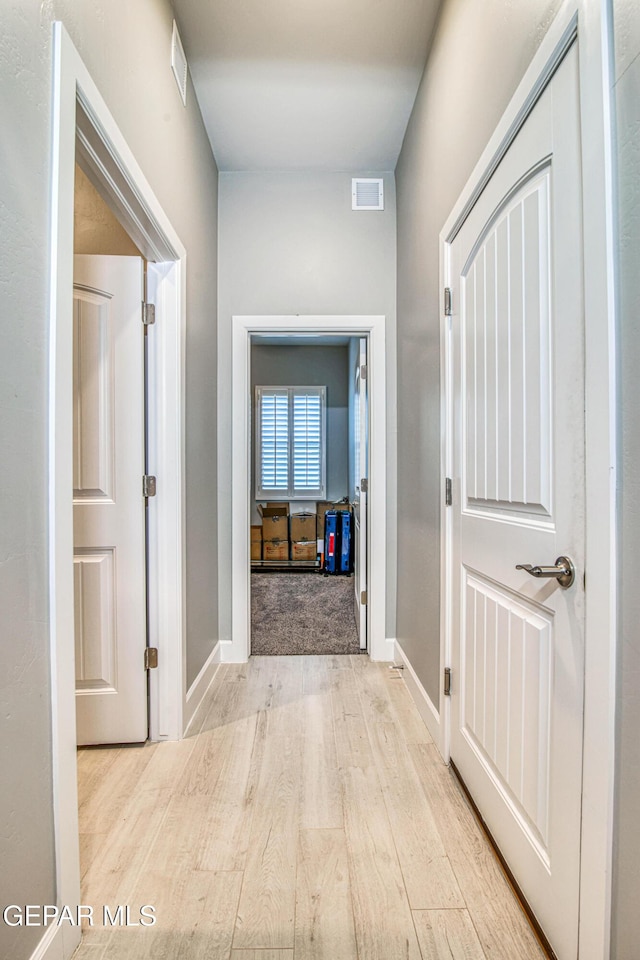 hallway with light hardwood / wood-style floors