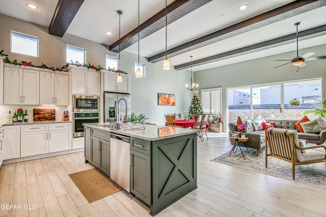 kitchen featuring a wealth of natural light, hanging light fixtures, white cabinets, and stainless steel appliances