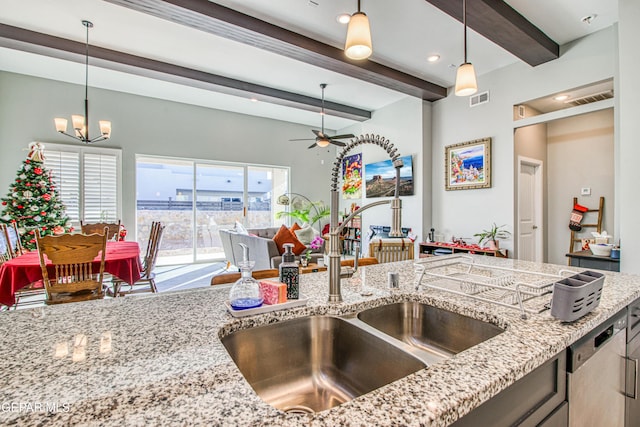 kitchen with sink, beamed ceiling, pendant lighting, and ceiling fan with notable chandelier