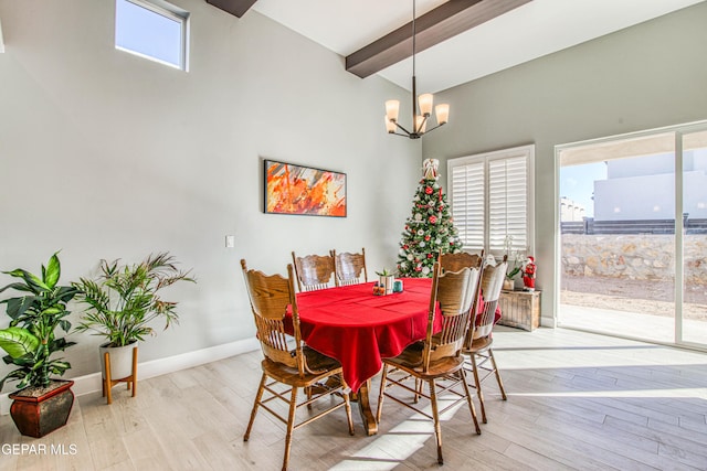 dining space featuring beam ceiling, an inviting chandelier, light hardwood / wood-style flooring, and a high ceiling