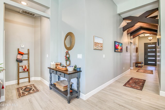 entrance foyer with beam ceiling and light hardwood / wood-style floors