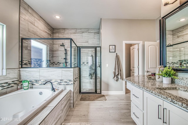 bathroom featuring vanity, wood-type flooring, and shower with separate bathtub