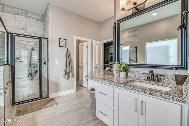bathroom featuring vanity, hardwood / wood-style flooring, and a shower with door
