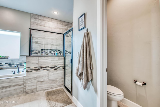 bathroom with toilet and shower with separate bathtub