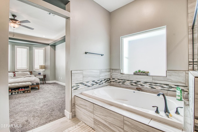 bathroom featuring hardwood / wood-style floors, tiled bath, and ceiling fan