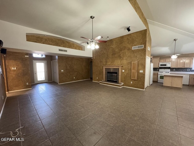 unfurnished living room with a fireplace, dark tile patterned floors, high vaulted ceiling, and ceiling fan