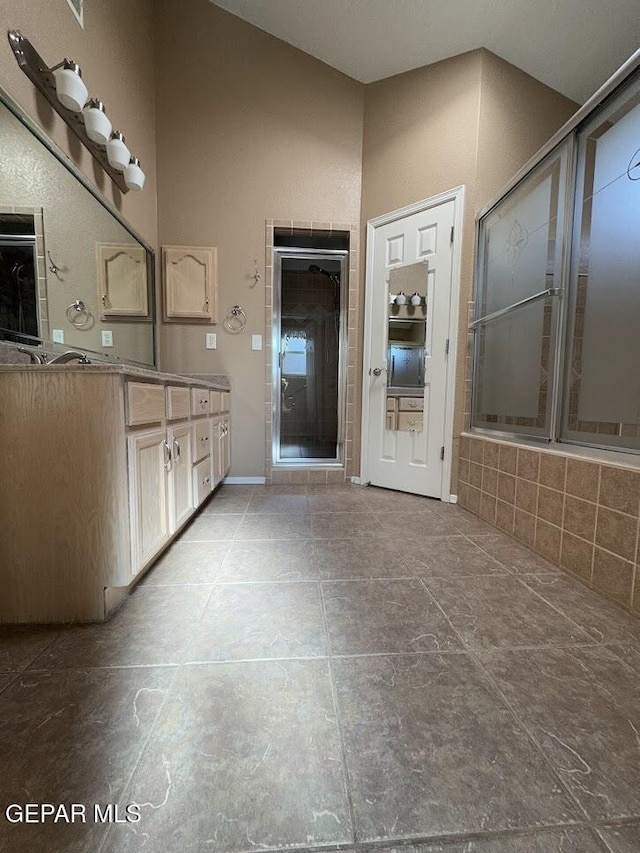 bathroom with tile patterned flooring, vanity, shower / bath combination with glass door, and lofted ceiling