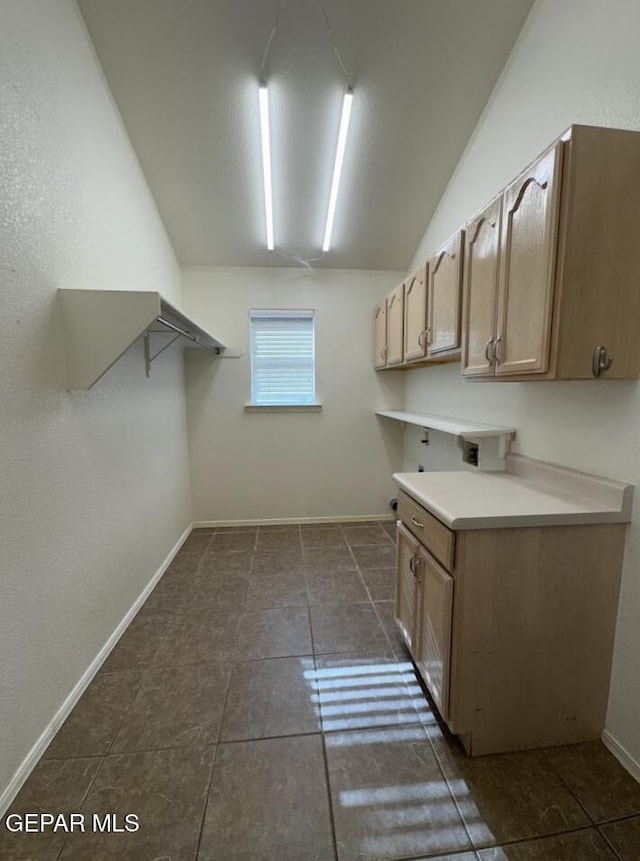 washroom with cabinets and dark tile patterned floors