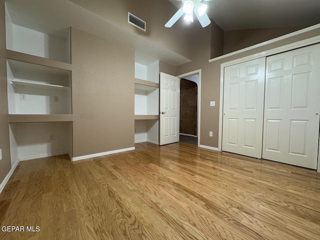 unfurnished bedroom featuring ceiling fan, light hardwood / wood-style floors, a closet, and vaulted ceiling